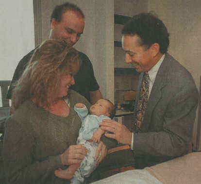 Photo – Don Burk/staff Michael Shorstein (right) is as proud as new parents Donna and Jerry over the adoption of baby Anthony.